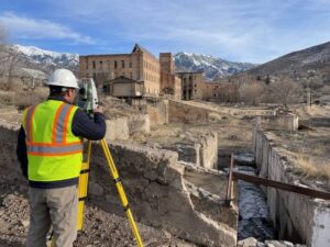 ALTA Surveyor measuring parcels and surviving structures at an old mill property in Ogden Utah